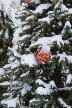 Christmas trees decorated with red balloons in front of the cafe entrance. Street New Year decorations.