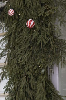 Christmas trees decorated with red balloons in front of the cafe entrance. Street New Year decorations.