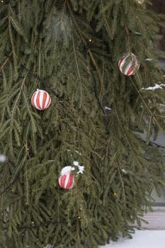 Christmas trees decorated with red balloons in front of the cafe entrance. Street New Year decorations.