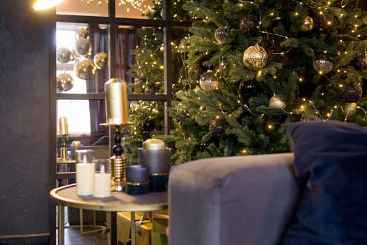 Christmas interior with a beautiful Christmas tree, sofa, light bulbs and dark background