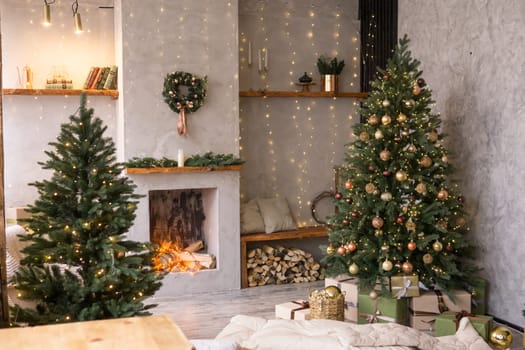The interior of the Scandinavian-style living room, decorated for the Christmas holidays. Christmas tree next to the fireplace
