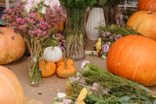 Flower arrangement in a pumpkin, autumn interior decor. Creating handmade autumn decor