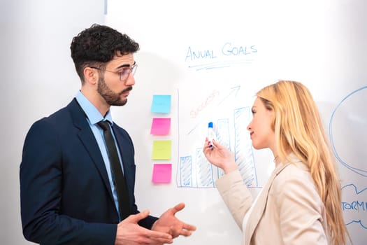 Two businessmen discussing project results on a whiteboard. Concepts of team, friendship and diversity.
