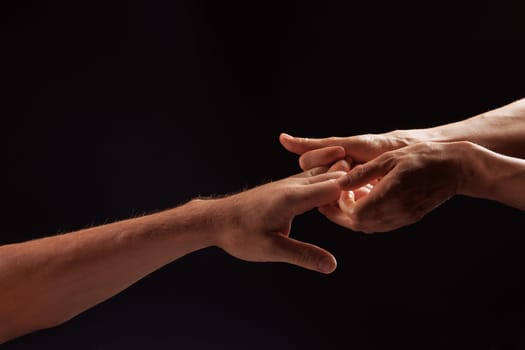 girl masseur doing hand massage to man on dark background close-up, beautiful relaxation massage, recovery