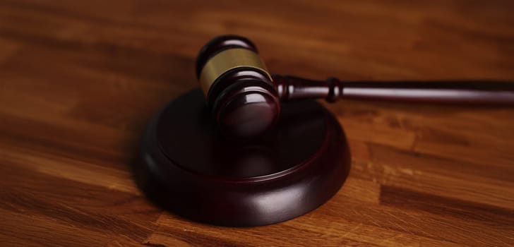 Close-up of judges wooden hammer on soundboard placed on wooden table. Attorney tool for legal service. Court, law, verdict, legality and justice concept