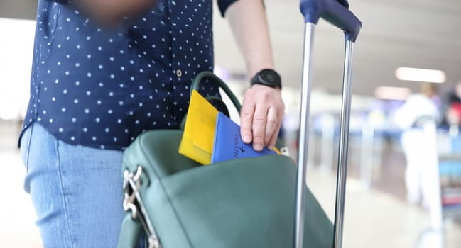 A man puts his passport and tickets in a suitcase, close-up, blurry. The passenger checks documents at the airport, travel,