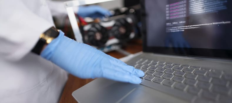 Close-up of professional technician man touching laptop keyboard wearing sterile gloves. Person check device on hidden failure. Tech maintenance concept