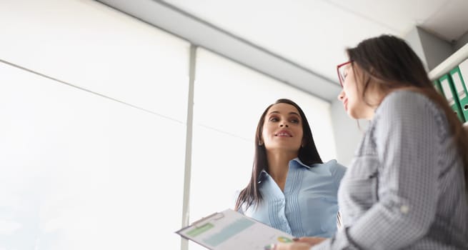 Portrait of female coworkers discussing report business growth and statistics. Colleagues in company office create strategy. Business, job, career concept