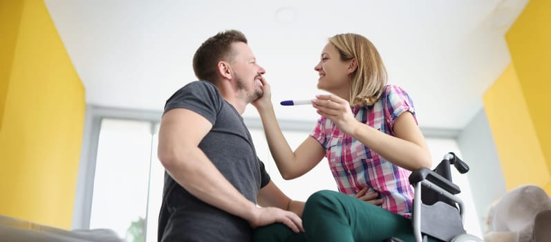 Portrait of happy husband got news about wifes pregnancy, waiting for baby, middle aged man smiles. Woman show positive pregnancy test. Family grow concept
