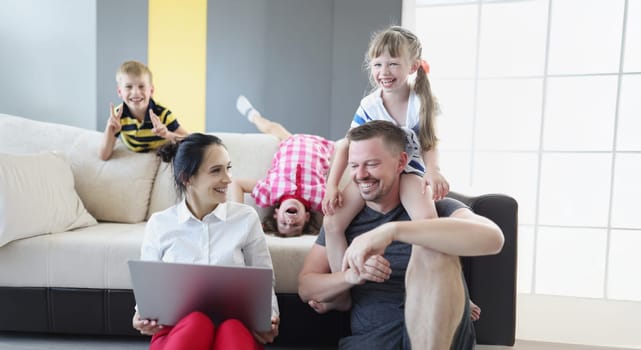 Portrait of happy smiling family spend time together in living room. Father mother and children laugh and go crazy. Family, childhood, parenthood concept