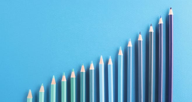 Top view of blue colored pencil set arranged in increasing way on surface and not exactly in row. Tool for draw your dreams, ideas and vision. Art concept