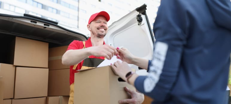 Portrait of courier and receiver make trade with signature on document for order. Worker delivered box fast on personal address. Delivery service concept