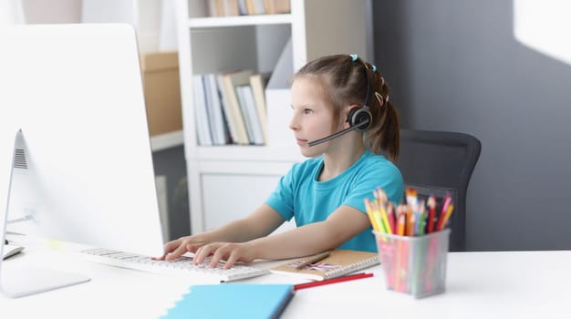 Portrait of girl busy with online school classes from home because of pandemic situation. Child wear headset for better result. Distance education concept