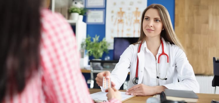 Portrait of qualified female doctor give tablets to patient for faster recovery. Woman on appointment get advice from professional. Medicine, help concept