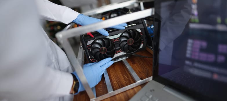 Close-up of man mechanic installing cooler fan with copper tubes on computer processor. Computer motherboard with all details. Technology, repair concept