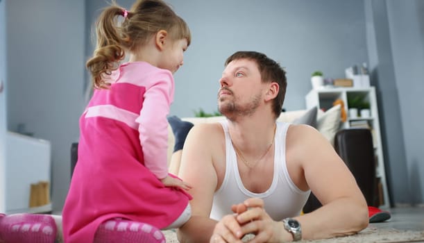 Portrait of father and daughter spending time together at home on holiday. Child spend quality time with parent. Childhood, parenthood, leisure concept
