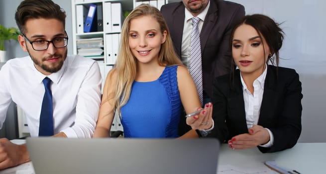 Portrait of group of people in office watch in laptop screen listen to speaker online. Watch internet video at workplace with workers. Fun at work concept