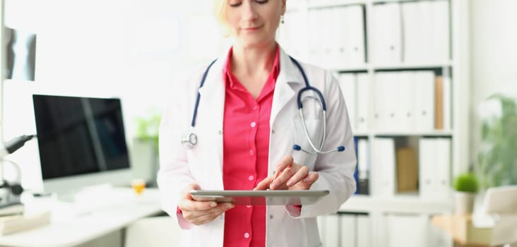 Portrait of professional medical worker use modern tablet device for work in clinic. Doctor in uniform hold new gadget. Development, healthcare concept