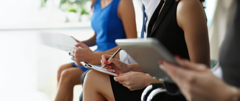 Close-up of group of people hold silver pens and pad ready to make marks while sit in row at seminar training. Executive coaching, presentation concept