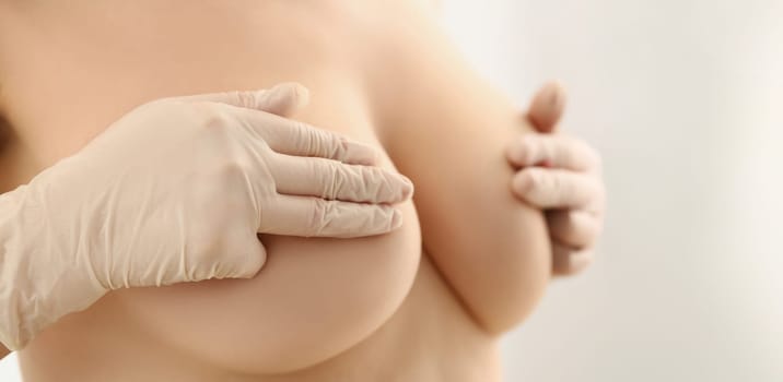 Close-up of womans body topless, cover breasts with hands, natural size of boobs. Womans decision to enlarge breasts. Plastic, cosmetic surgery concept