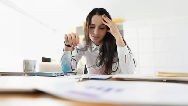 Portrait of tired overworked woman suffer with headache on workplace in office. Stressful and exhausted clerk in office. Hardworker, businesswoman concept