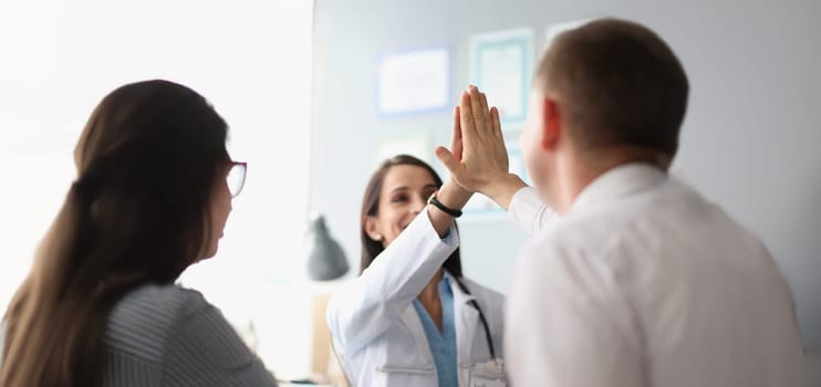 Portrait of colleagues give high five after successful agreement with partners. Happy coworker celebrating deal in office. Growth, business, career concept
