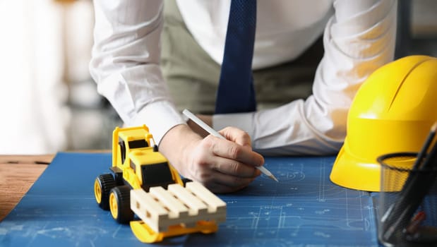 Close-up of male worker making corrections in construction planning with pencil. Qualified forewoman and blueprint on workplace. Renovation, build concept