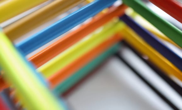 Close-up of pyramid shape made with some different colored wood pencil crayons. Tools for drawing and express your vision. Art, creativity, hobby concept