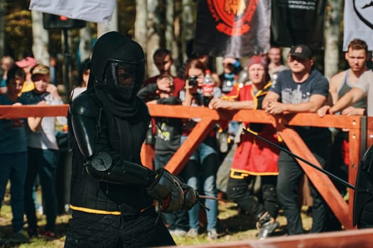 Medieval knight in black clothes with a sword. Reconstruction of medieval battles. Festival of medieval culture. Bishkek, Kyrgyzstan - October 13, 2019