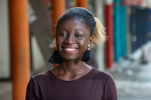 young girl standing in purple tee-shirt looking at camera smiling.