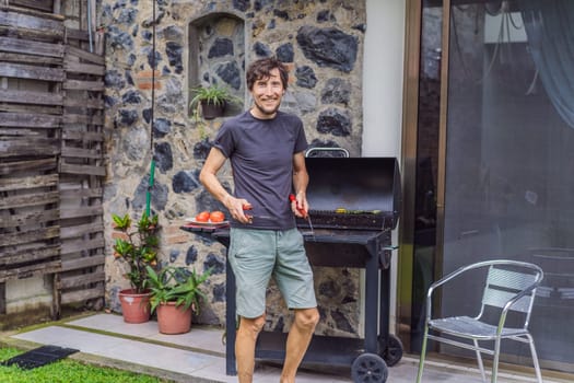 Man cooking dinner on a barbecue in his backyard. Outdoor cooking, home lifestyle, and family time concept.
