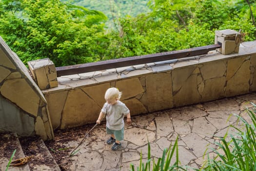 Toddler playing with a stick and leaves in the park. Childhood curiosity, nature exploration, and playful moments concept.