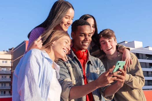 Group of friends using looking at their smartphones Multiracial teenagers browsing the internet with mobile phone on campus