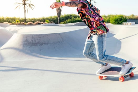 unrecognizable stylish skater in jeans and sneakers practicing skills with skateboard in skatepark on sunny day in summer