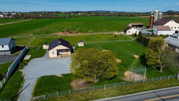 Ronks, Pennsylvania, USA, April 9, 2024 - A vast expanse of open farmland an Amish one room school house surrounded by lush green pastures and a clear blue sky. The property showcases a serene rural setting, ideal for country living