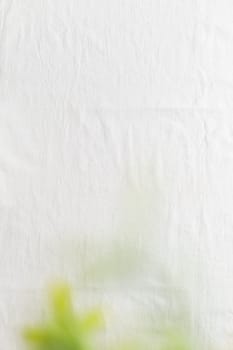Fine bright linen cloth with green leaves. The tablecloth on top view. Background for wedding and birthday celebrations in natural style with space for text
