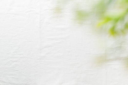 Fine bright linen cloth with green leaves. The tablecloth on top view. Background for wedding and birthday celebrations in natural style with space for text