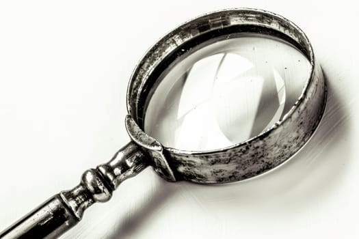 Close up of a magnifying glass isolated on a clean white background for enhanced visual focus