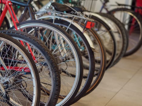 Bikes parked in a row, ready for a ride through the city streets and parks, symbolize urban living and eco friendly commuting. Lights, reflectors, helmets, and brakes ensure a safe ride for all ages