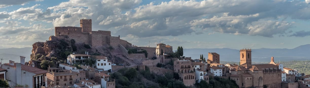 Scenic panoramic view of Vilafames with its illuminated castle and old town at dusk, highlighting its medieval architecture and enchanting atmosphere.