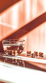 Glass of water with medicine capsules in sunlight symbolizes health and wellness, highlighting the importance of medication in healthcare