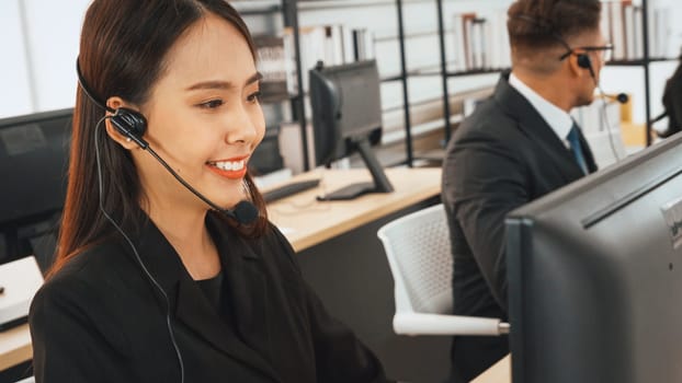 Business people wearing headset working in office to support remote customer or colleague. Call center, telemarketing, customer support agent provide service on telephone video conference call. Jivy