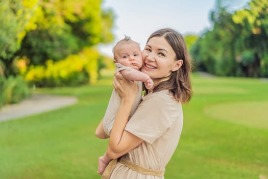 A happy 40-year-old mother cradles her newborn in a sun-drenched park. Love, family and generations in harmony.