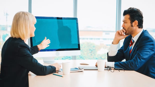 Business people in the conference room with green screen chroma key TV or computer on the office table. Diverse group of businessman and businesswoman in meeting on video conference call . Jivy