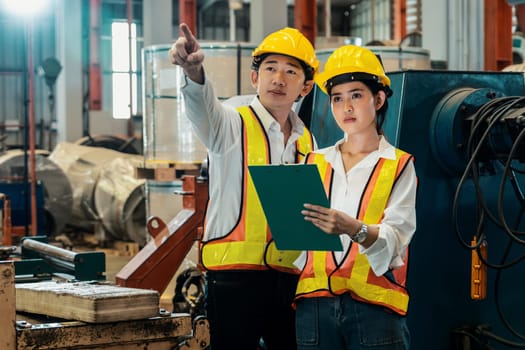 Professional quality control inspector conduct safety inspection on machinery and manufacturing process in factory. Engineers overseeing process optimization in heavy industry facility. Exemplifying