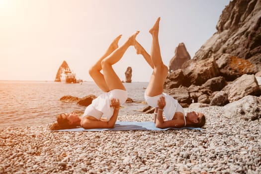 Woman sea yoga. Back view of free calm happy satisfied woman with long hair standing on top rock with yoga position against of sky by the sea. Healthy lifestyle outdoors in nature, fitness concept.