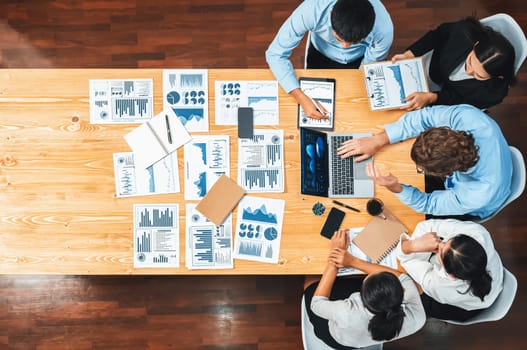 Panorama top view diverse group of business analyst team analyzing financial data report paper on meeting table. Chart and graph dashboard by business intelligence analysis. Meticulous