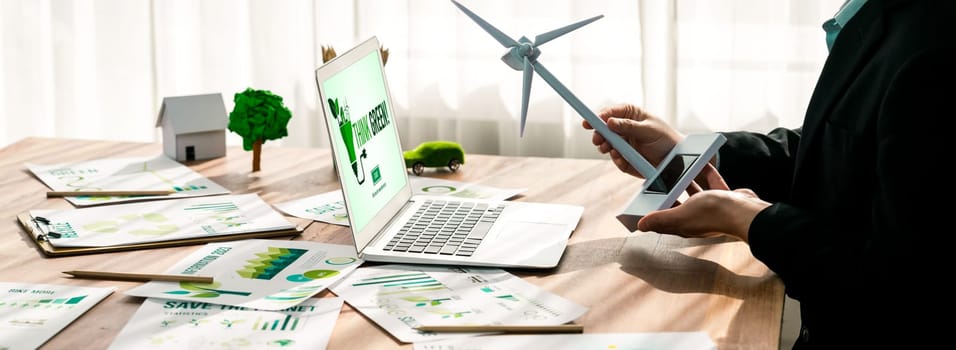 Businessman in green corporate company planning eco-friendly and environmental conservative to reduce CO2 and implement net zero policy in meeting room with eco idea on laptop screen. Trailblazing