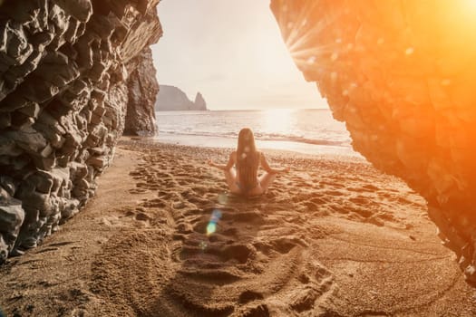 Middle aged well looking woman with black hair doing Pilates with the ring on the yoga mat near the sea on the pebble beach. Female fitness yoga concept. Healthy lifestyle, harmony and meditation.