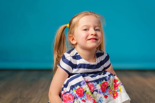 Funny little toddler girl smiling against blue background